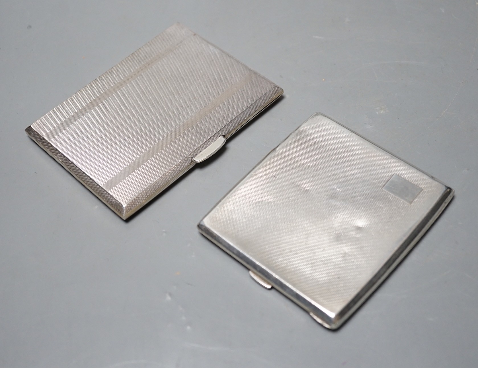 Two engine turned silver cigarette cases, largest 11.2cm